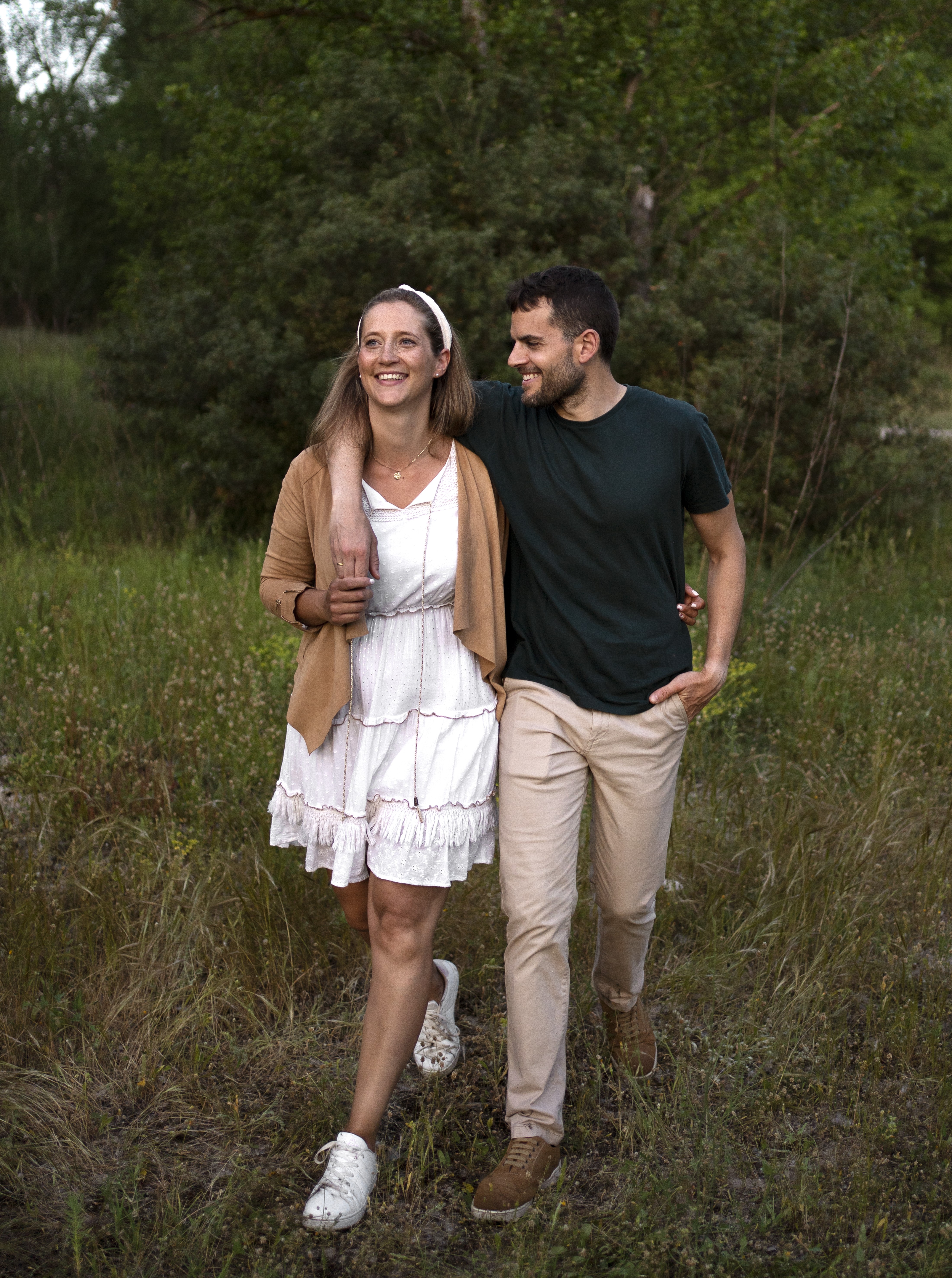 A couple walking together through a green nature landscape